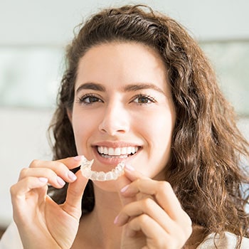 A female patient putting in Invisalign