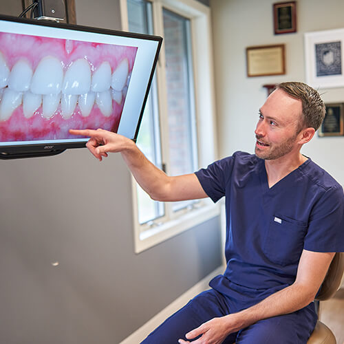 Dr. Hays pointing at some dental implants